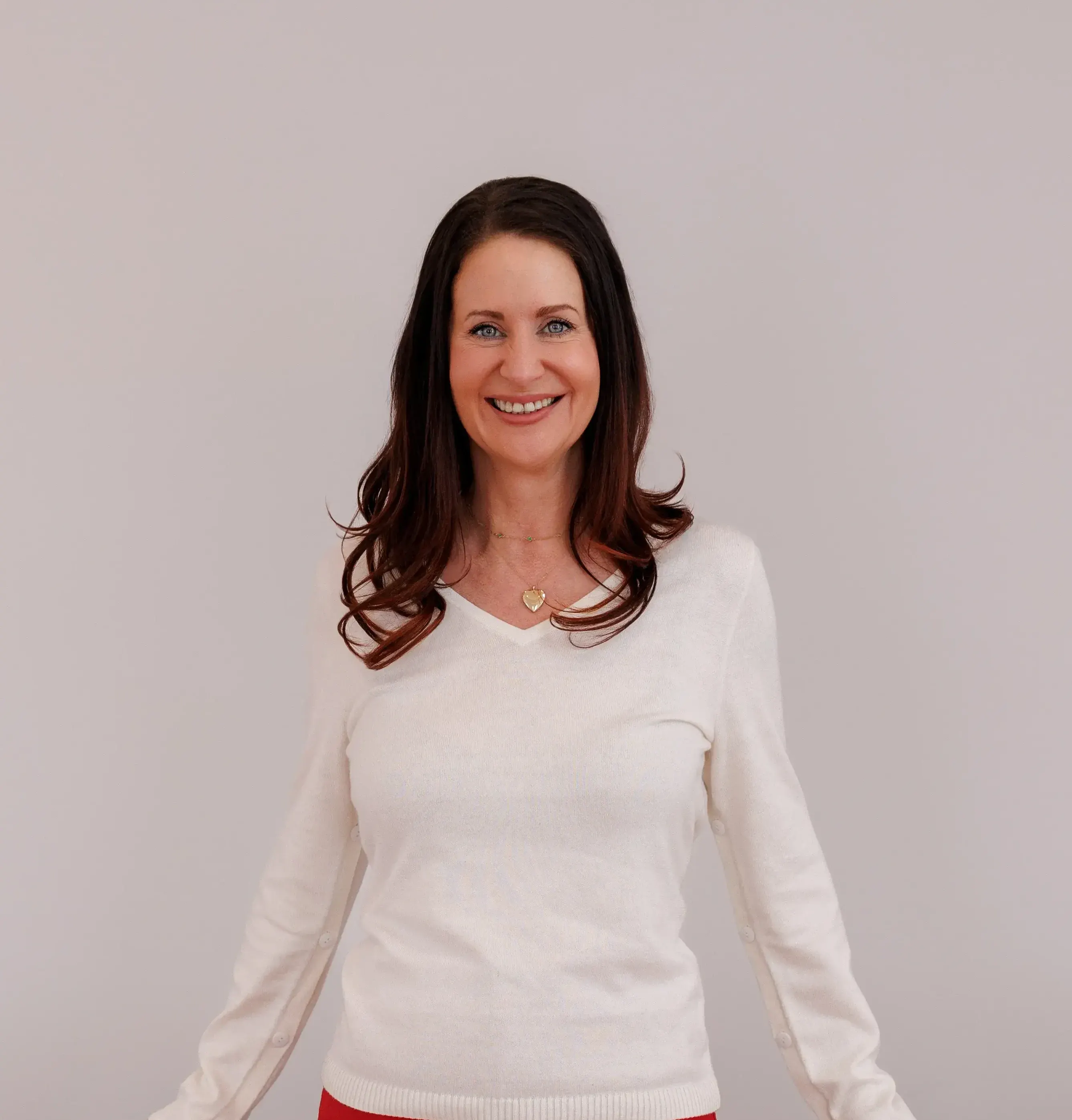 Amy Nunn, founder of Anu Aesthetics and Wellness, smiling in white sweater at Elizabethtown clinic